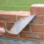 bricklayer's trowel and brick wall under construction bricklayer's trowel and brick wall under construction